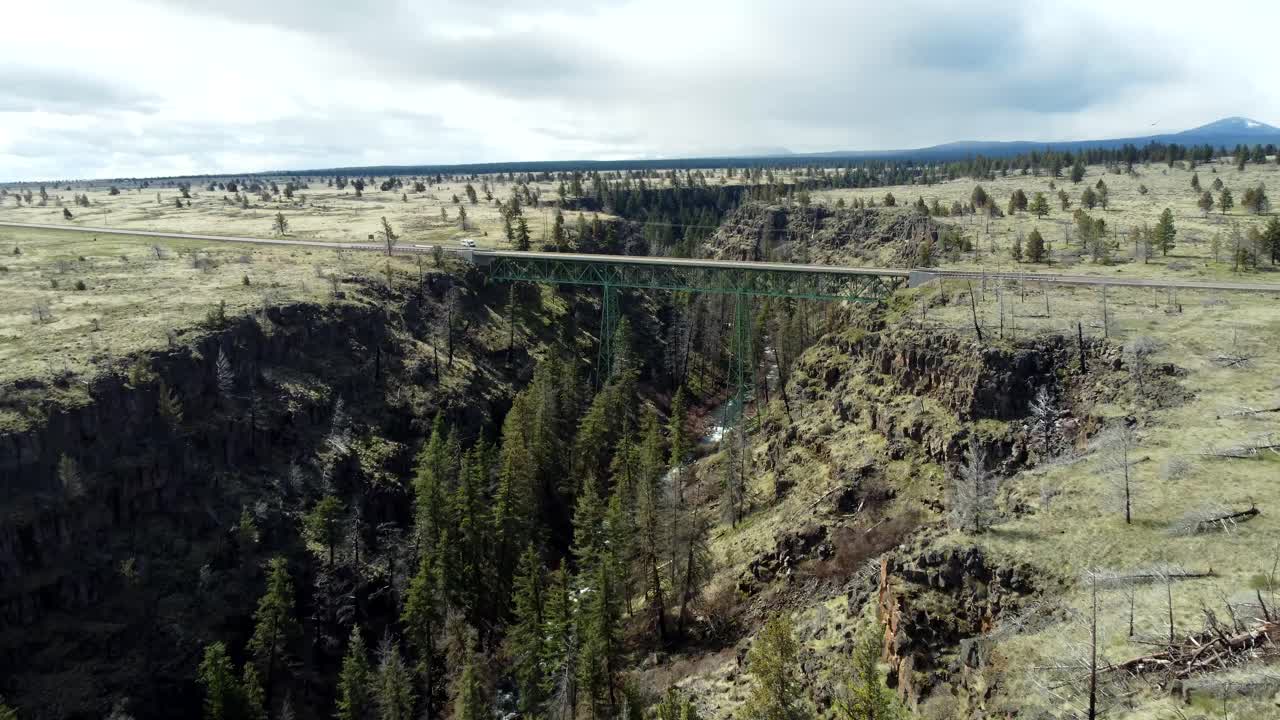 Drone view of a steel bridge crossing Highway 26 over Mill Creek in a gorge-canyon in central Oregon in spring