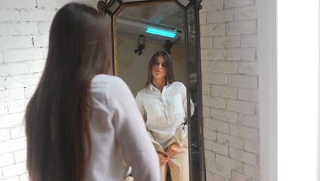 mujer probando ropa delante de un espejo