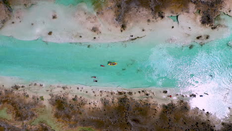 cinematic downward angle drone shot of kayakers in clear blue waters at bacalar mexico