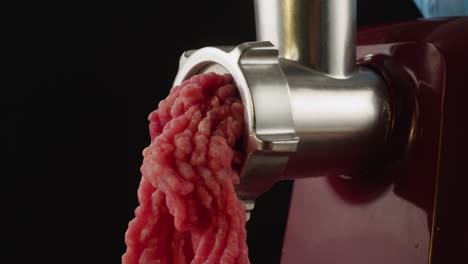 carne picada que sale de un molinillo de carne