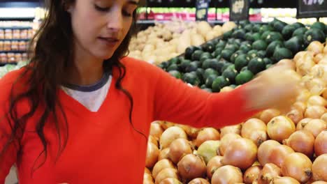 woman buying onion in supermarket