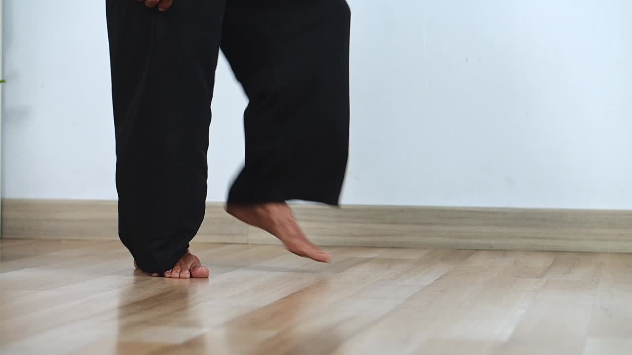 Focused elderly asian man demonstrating martial arts stance with intense gaze