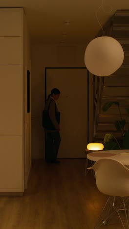 woman walking through a modern apartment at night