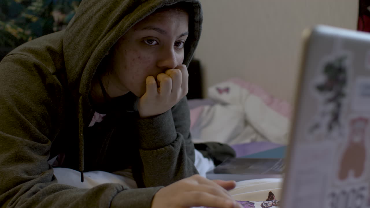 Teenage Girl Using Laptop in Bedroom