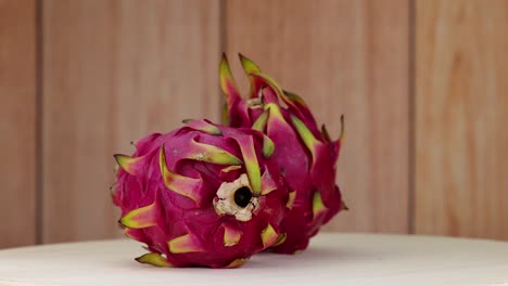 dragon fruits rotating on a wooden surface