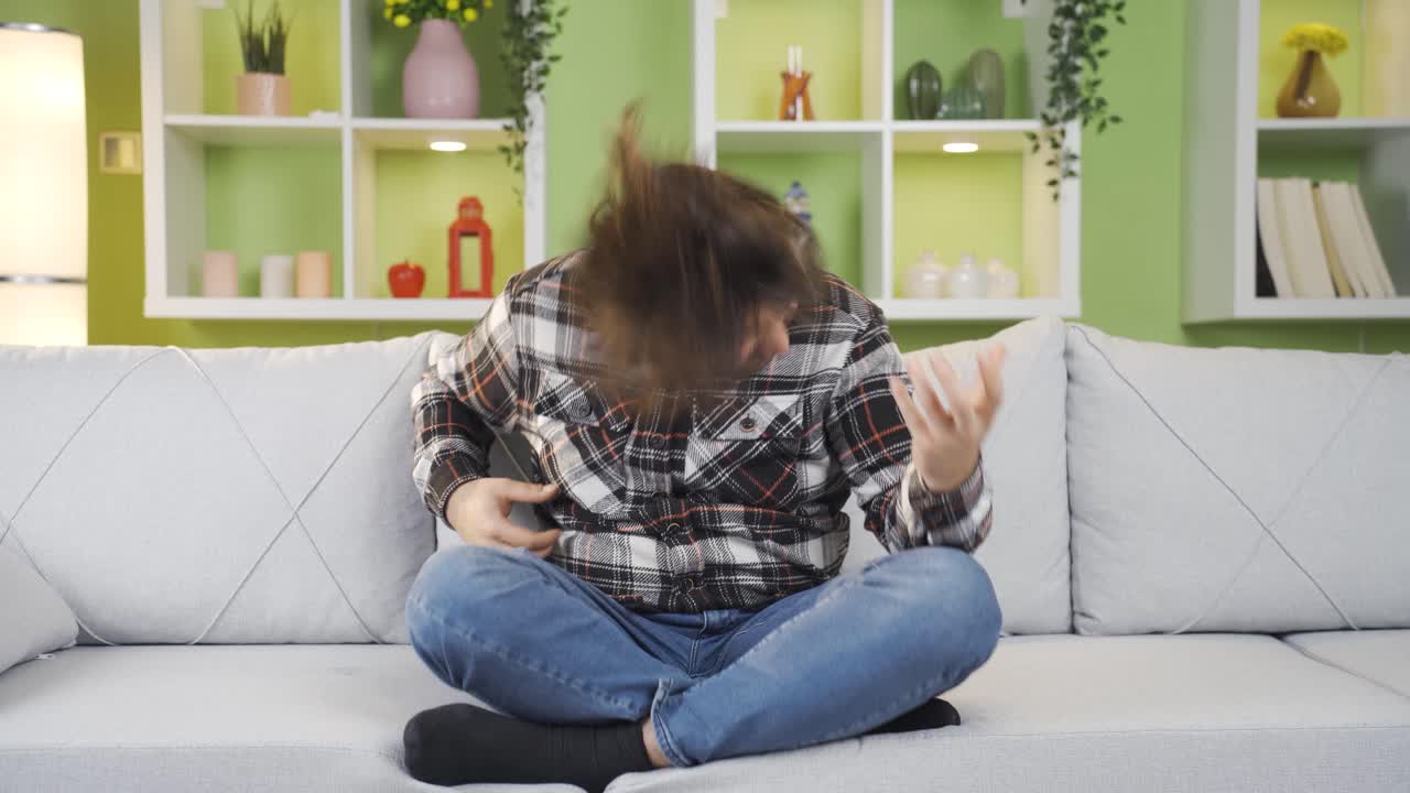 활기차고 과잉 활동적인 젊은이가 집에서 재미를 느끼고 있습니다.