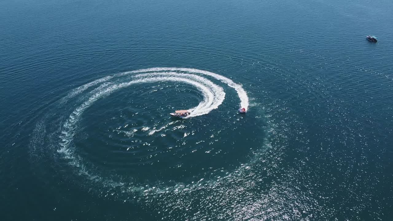 모터 보트는 견인 뗏목을 타고 관광객을 원형으로 돌립니다.