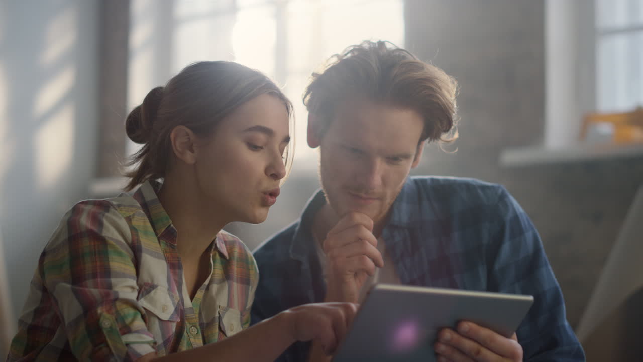 una pareja enfocada haciendo un proyecto de reparación en una tableta. concepto de renovación moderno.