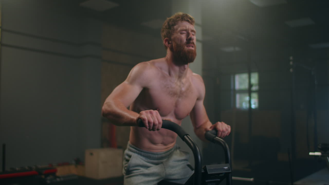 피트니스  ⁇  에서 정지 된 자전거 를 타고 피로 를 극복 하는 튼튼 한 사람