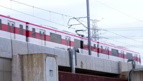 Ein-Blick-Von-Unten-Auf-Einen-Vorbeifahrenden-Monorail-Skytrain,-Der-Auf-Der-Linken-Seite-Des-Bildes-In-Bangkok,-Thailand,-Ausfährt