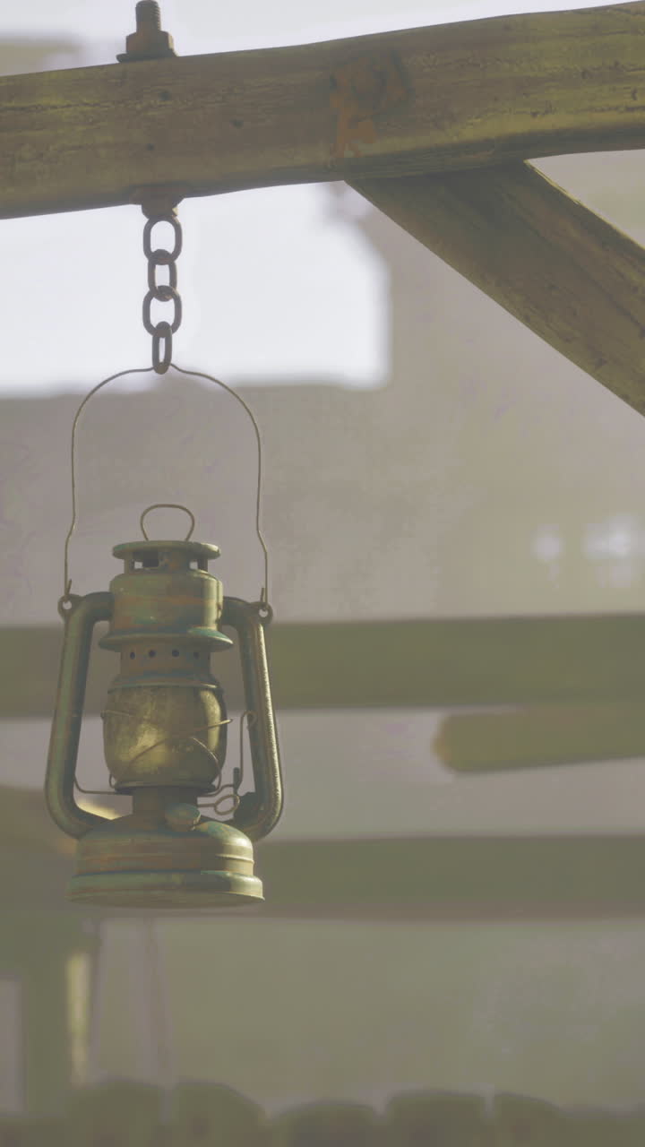 Vintage lantern hanging in an old wooden structure during early morning light