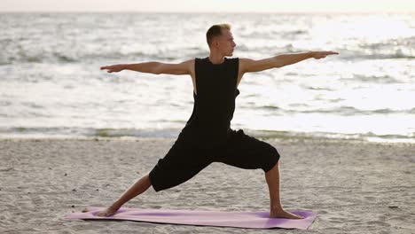 a young man practices yoga while standing on a sports mat at dawn. performing a specific exercise. body stretch. free time, rest