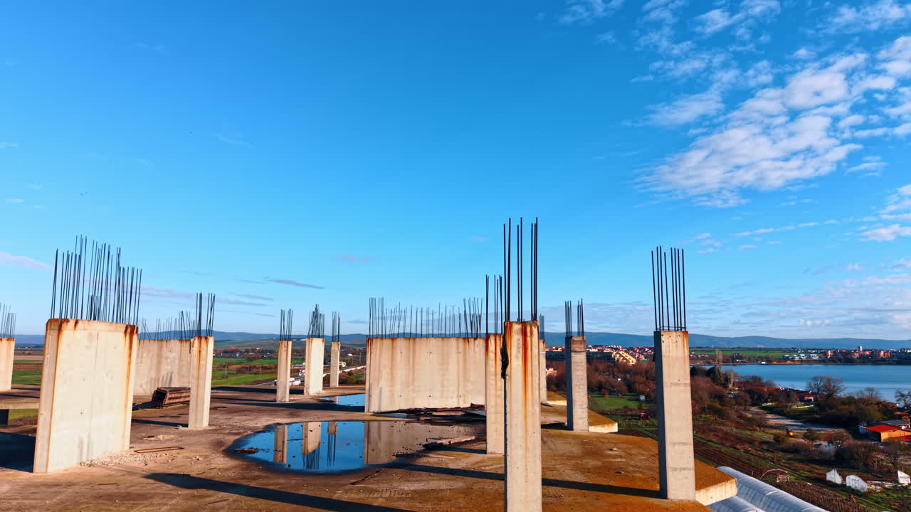 Sollevati sopra la cima dell'edificio in costruzione, rivelando la vista sull'area residenziale sulla riva del mare.