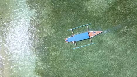 blue excursion boat anchors in front of the beach marvelous aerial view flight top-down bird's eye view drone footage of gili air beach indonesia at summer 2017 cinematic from above by philipp marnitz