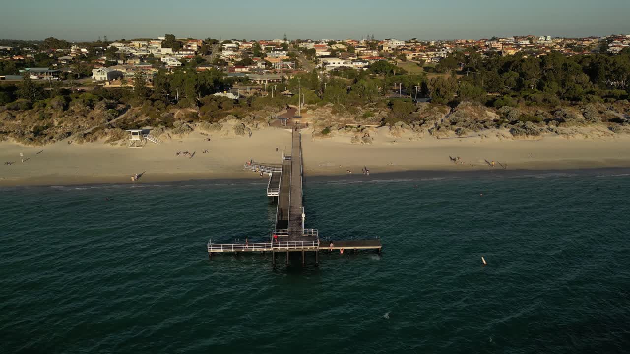 tomada aérea de la gente en el muelle de coogee beach en la ciudad de perth durante la hora del atardecer dorado, australia occidental - tomada en órbita de un avión no tripulado