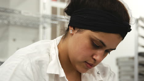 Hispanic-woman-working-in-a-bakery,-head-and-shoulders