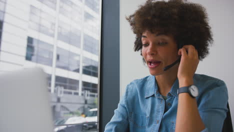 Joven-Empresaria-En-Una-Oficina-Moderna-Trabajando-En-Una-Computadora-Portátil-Usando-Auriculares-Inalámbricos