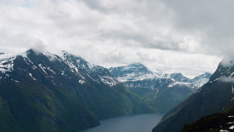 Norwegian-fjord-with-dramatic-clouds-surrounding-mountain-peaks-at-the-west-coast-of-Norway-at-Sunnmøre,-Liavarden