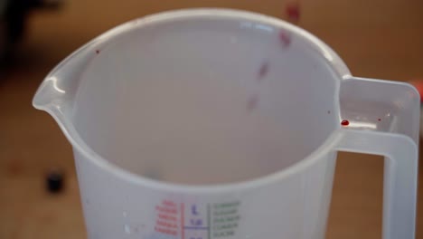 high angle closeup of berries falling into a liter measure in slow motion, with motion blur while falling