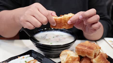 홍콩에서 반죽 막대기를 콘지에 담그는 것