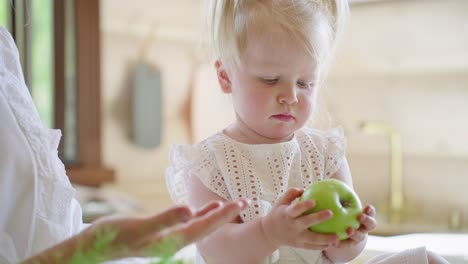 toddler and apple in kitchen