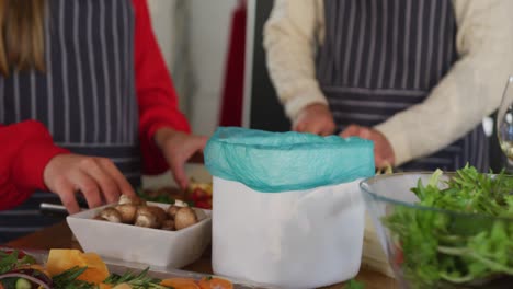 video of happy caucasian couple peeling vegetables in the kitchen