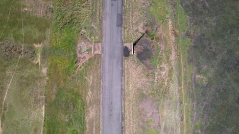 top down aerial view tracking along empty road through lush natural landscape, apure, venezuela