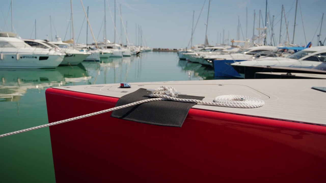 Yacht rosso legato con una corda bianca in un porto turistico di lusso