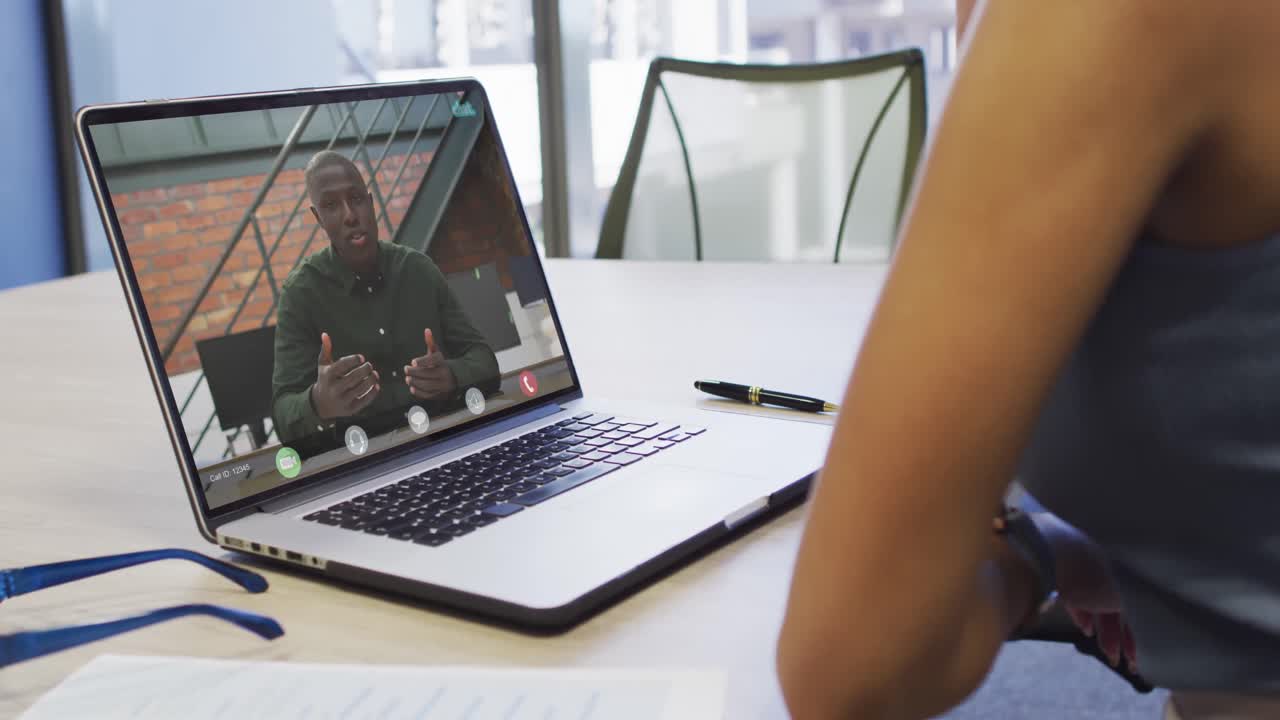 Video of african american woman having video call on laptop with african american male coworker