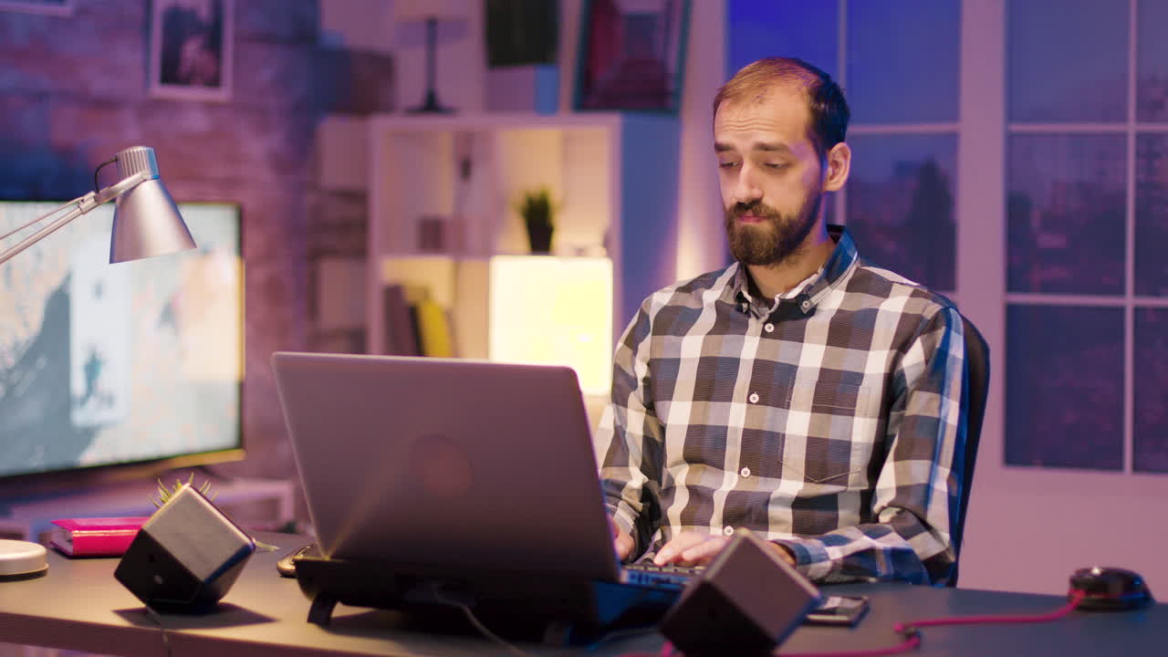 hombre trabajando en la computadora portátil en casa por la noche