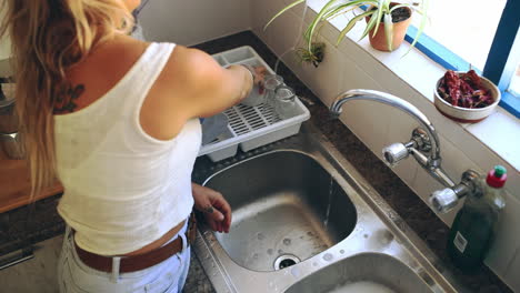 an attractive young woman washing the dishes