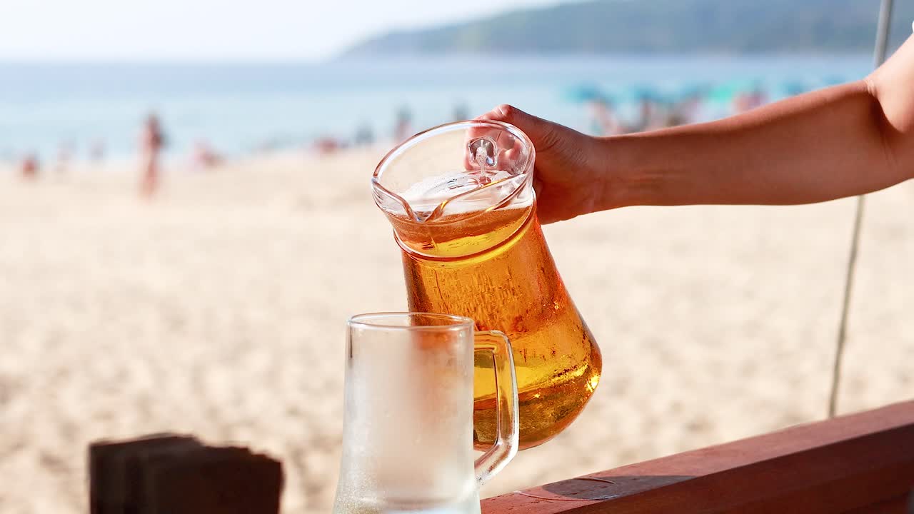 Birra versata su una spiaggia soleggiata