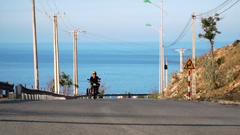 driving up scenic road in vietnam with yellow surfboard attached to surf rack