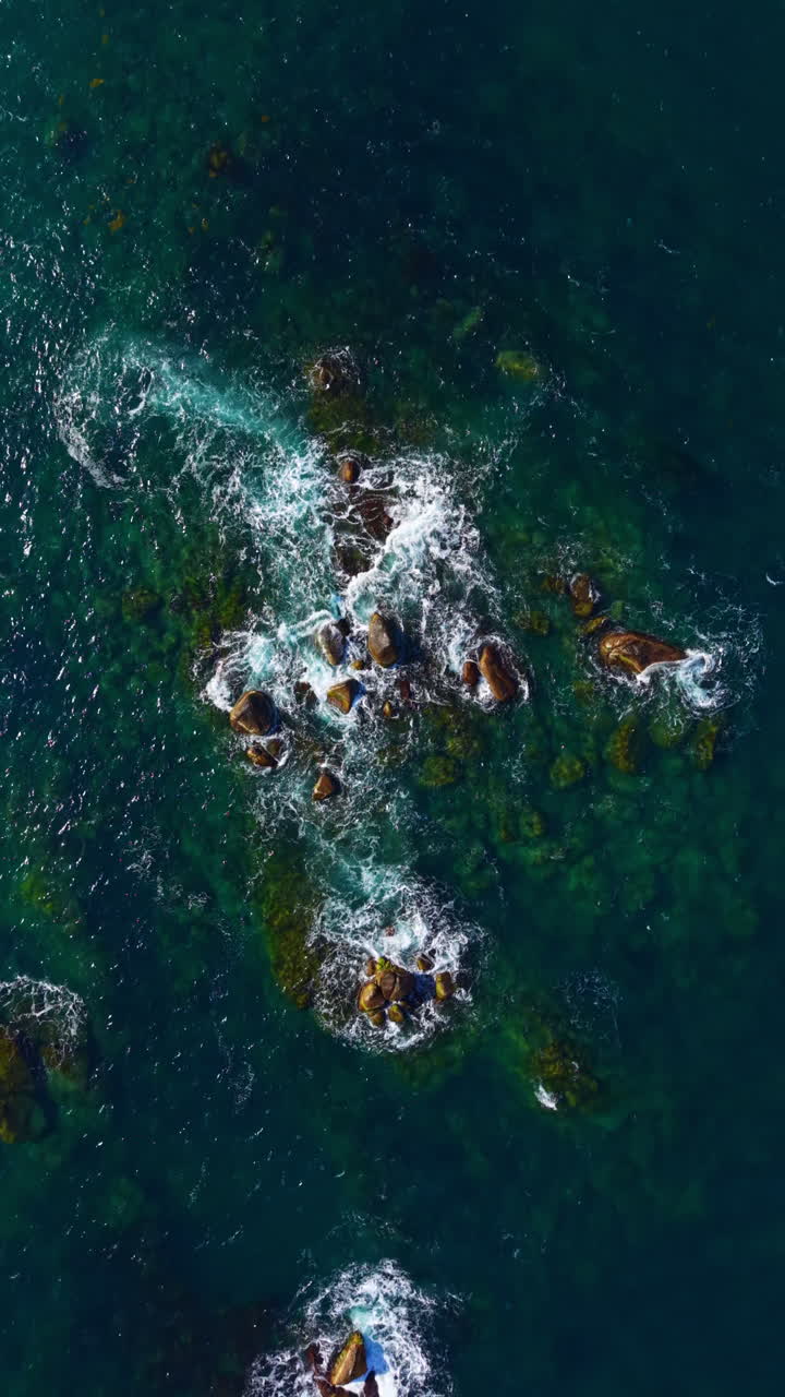 Waves crash against rocky outcrops in a serene coastal scene during golden hour, revealing the beauty of nature's patterns and colors