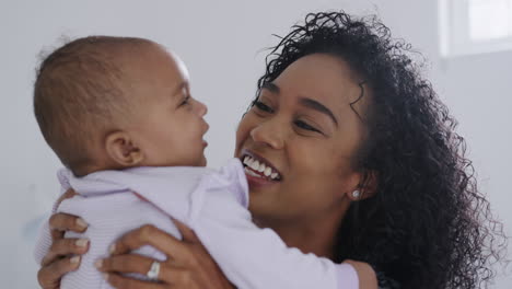 Loving-African-American-Mother-Wearing-Pyjamas-Playing-With-Baby-Daughter-In-Bedroom-At-Home