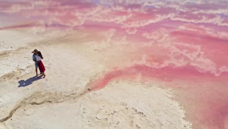 lovebirds tourists kissing on white salty lake coast