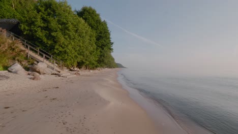 Knäbäckshusen-Strand-In-Österlen-Mit-Treppe-Und-Häuschen-Bei-Den-Buchen-Am-Sommermorgen,-Weitschuss-Nach-Vorne