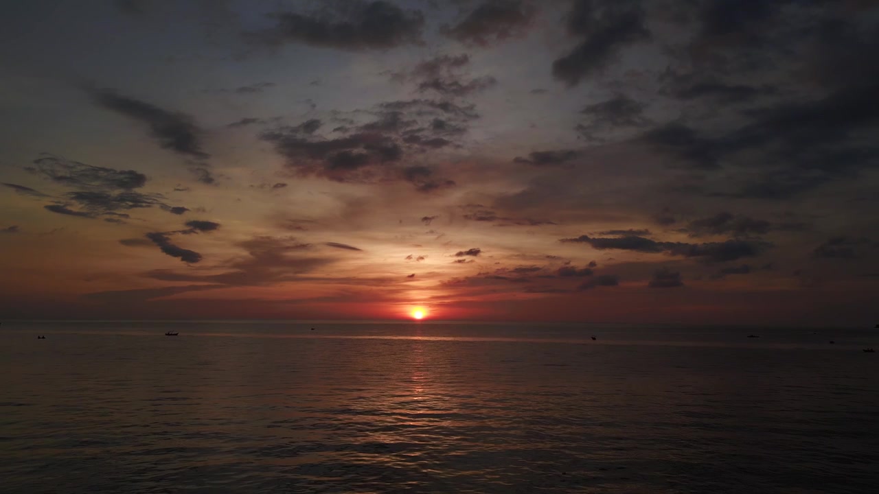 The sun as a small round ball in the center. Nice aerial view flight dream sunset at lonely Beach paradise island koh chang, thailand 2022. fly reverse drone
4k uhd cinematic footage.