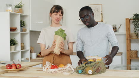 multiethnic couple bringing and unloading groceries at home