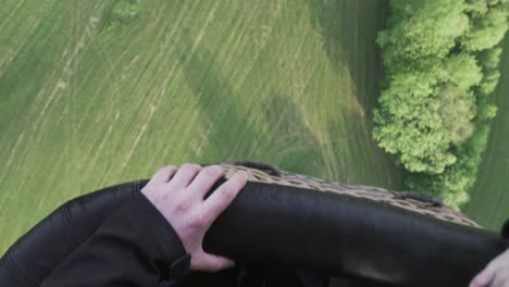 close-up of hands holding wicker basket of hot air balloon during first flight, cinematic shot of emotions in the sky