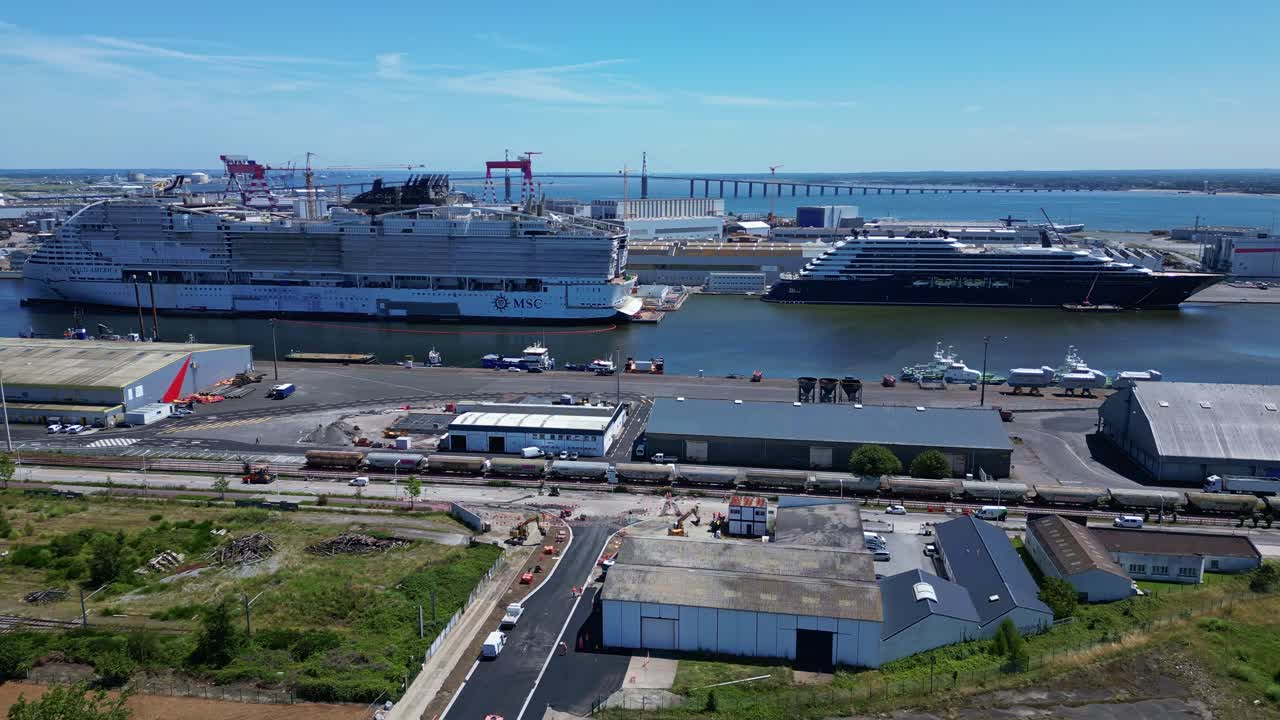 The industrial port of Saint-Nazaire with two magnificent boats, France. Aerial drone sideways