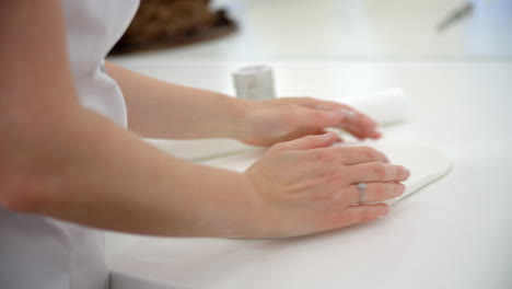 woman in bakery rolling out royal icing for cake decoration