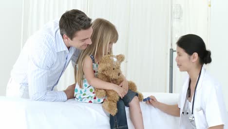 asian doctor checking little girls reflexes