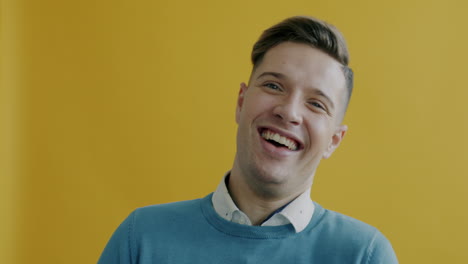 smiling man in front of a yellow background