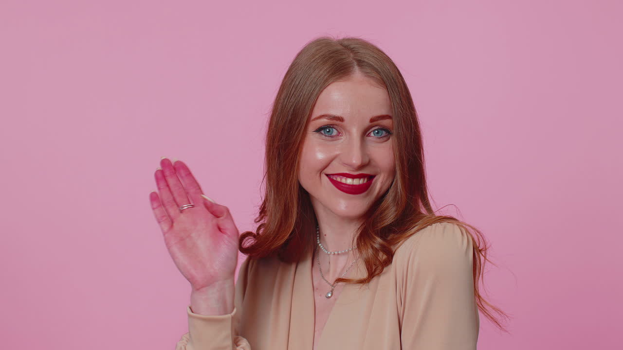 chica adolescente sonriendo amistosamente a la cámara y agitando las manos gestando hola o adiós, bienvenida