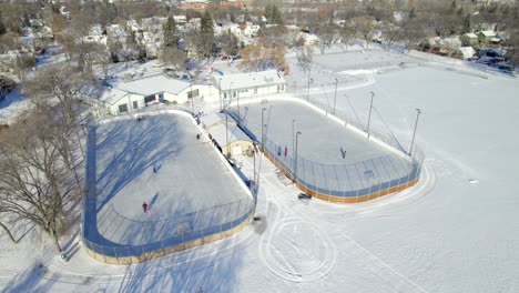 Vista-Aérea-De-Pistas-De-Hockey-Sobre-Hielo-Al-Aire-Libre-Y-Centro-Comunitario-En-Winnipeg,-Canadá,-4k