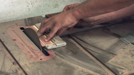 sliding shot of a carpenter's hands using a sanding tool to shape a piece of wood