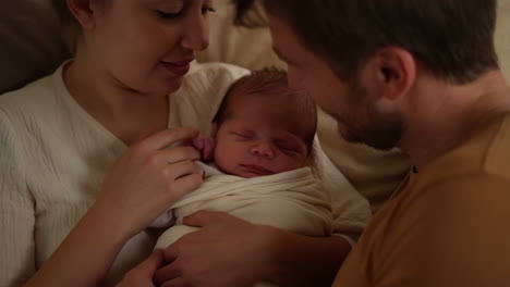 parents tenderly holding their newborn baby