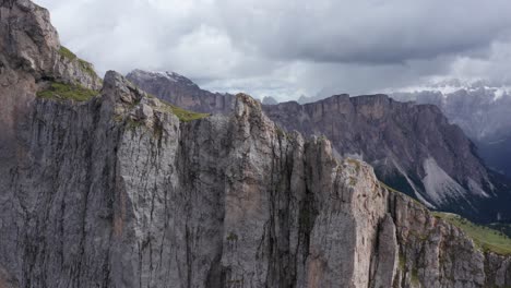 seceda ridge with reveal of rain storm in dolomite mountains, close up aerial view