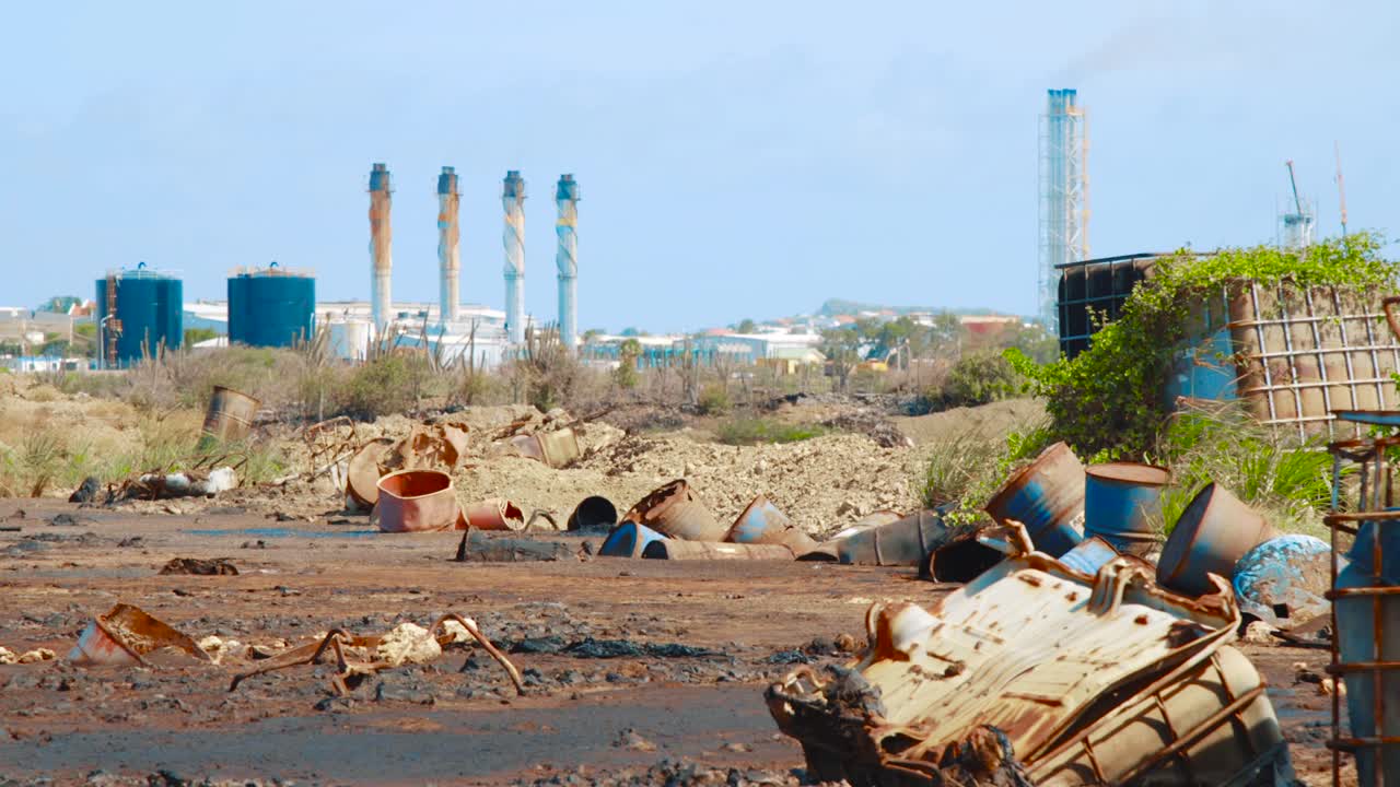 primer plano de barriles con tanques de petróleo crudo y agua sobre un lago de asfalto